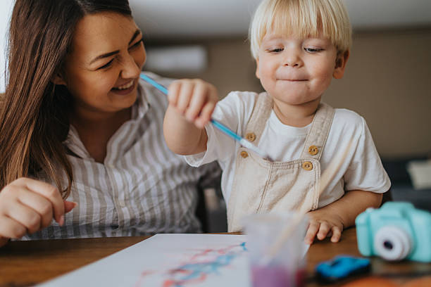 istock Mother and son painting at home 2207895513
