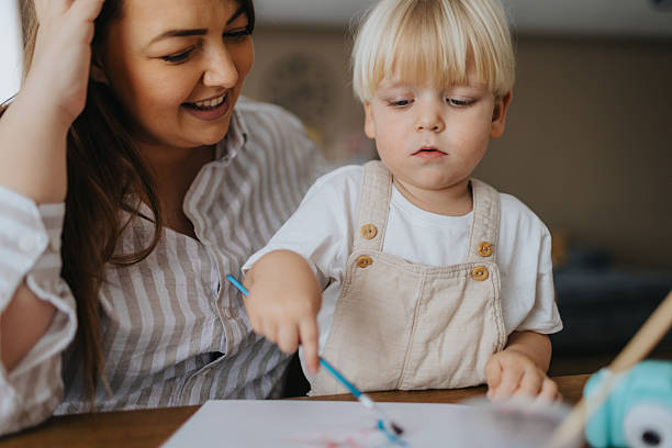 istock Mother and son painting at home 2207895610