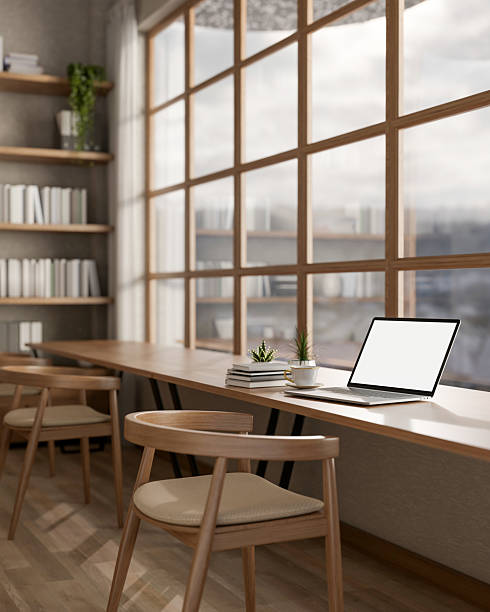 istock White screen laptop on long table under a glass wall next to large bookshelf. library or study room 2207895637