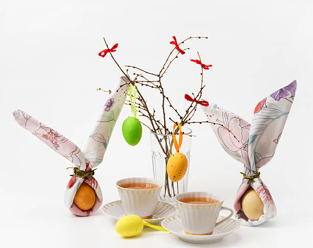 istock Vintage tea cups and Easter decorations on white background. White cups and eggs decorated with napkins in the form of hares on white background 2207897813