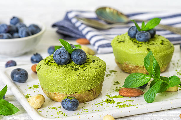istock Matcha vegan cheesecakes with blueberries and mint on white plate with nuts and green tea powder. Raw vegan cakes with fresh berries. Healthy vegan dessert 2207901028