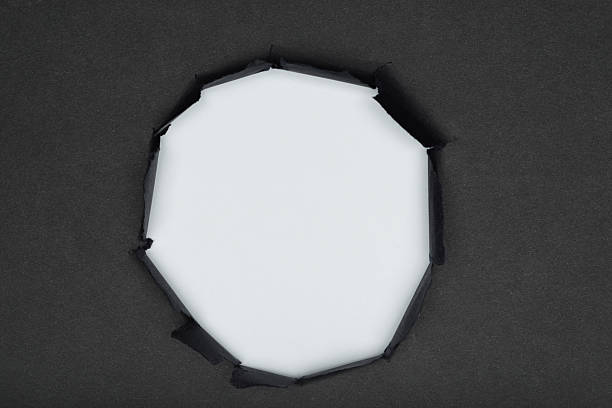 istock Center torn hole in black paper revealing white background, space for text 2207901212