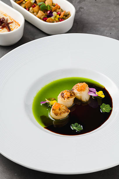 istock Scallops with two types of sauces and caviar on top 2207902337