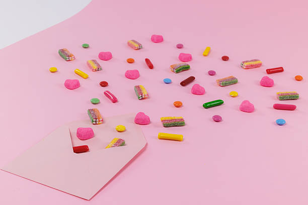 Young man about to eat a spoonful of colorful plastic beads, Microplastics concept