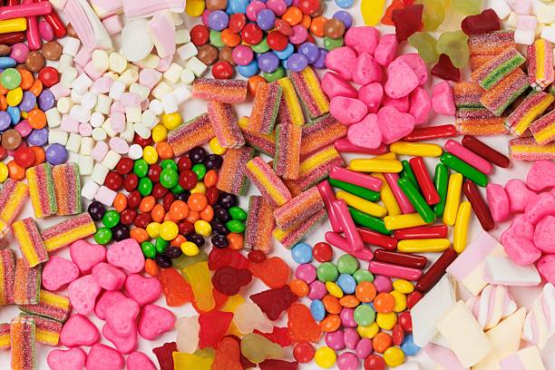istock Assortment of multicolored candies on a stripe shape on white background 2207902890