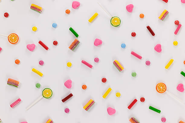 Assortment of multicolored candies on a stripe shape on white background