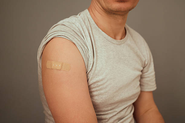 istock Individual shows their arm with a bandage taped over a recent vaccination site, highlighting the importance of immunization in a health-conscious environment 2207905935