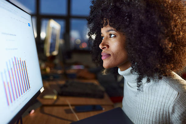 istock Black female programmer reading charts on PC in the office. 2207907185