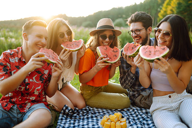 istock Happy friends eating watermelon on a picnic. 2207908358