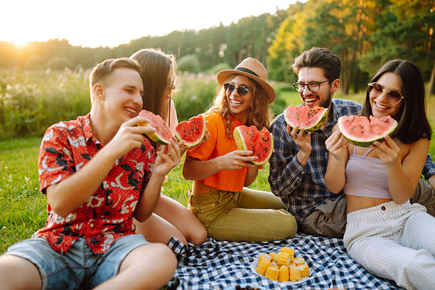 istock Happy friends eating watermelon on a picnic. 2207908381