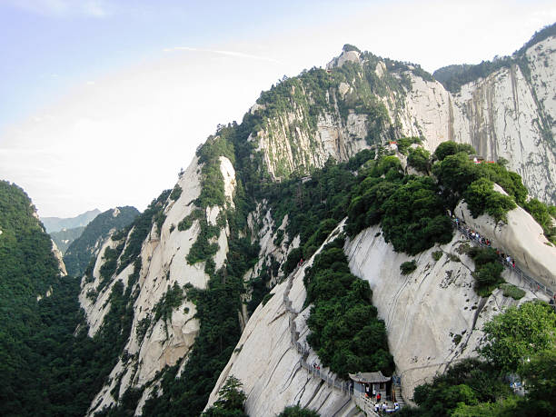istock Mount Huashan. Unrecognizable crowd of people walking on the steep steps built on the cliffs. Shaanxi Province. China. 2207908681