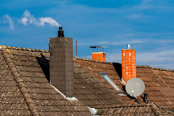istock Chimneys on rooftops and satellite dish under a  blue sky. 2207909924