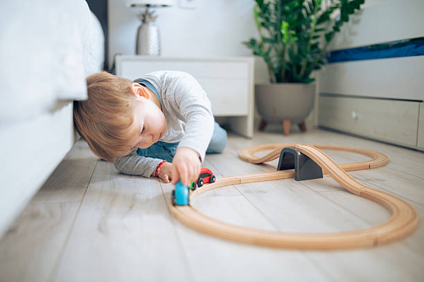 Joyful kid playing with a wooden train.