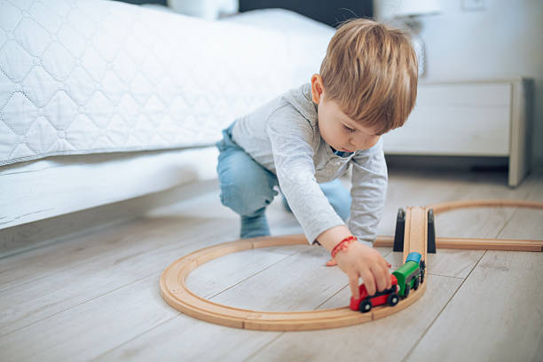 istock Little boy having fun with a wooden train. 2207910118