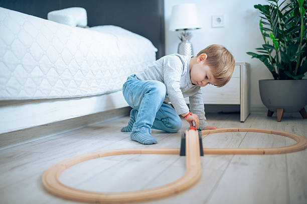 istock Little boy having fun with a wooden train. 2207910120