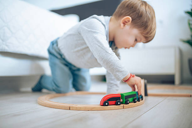 istock Little boy having fun with a wooden train. 2207910126