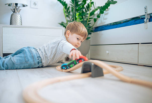 istock Cute little boy playing with wooden train. 2207910131