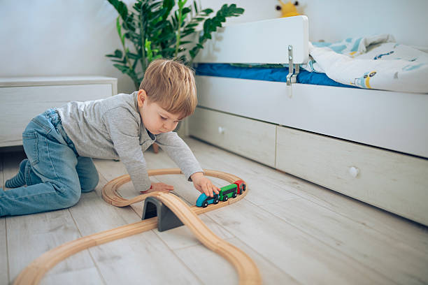 istock Cute little boy playing with wooden train. 2207910143