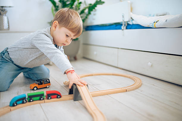 istock Cute little boy playing with wooden train. 2207910144