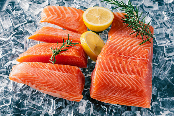 istock Fresh High-Quality Salmon Fillets with Lemon and Rosemary on Ice for Culinary Presentation 2207911263