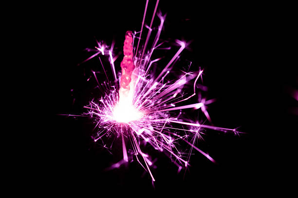 istock Bright Pink Sparkler Creating Explosions of Light Against Black Background at Night 2207911342