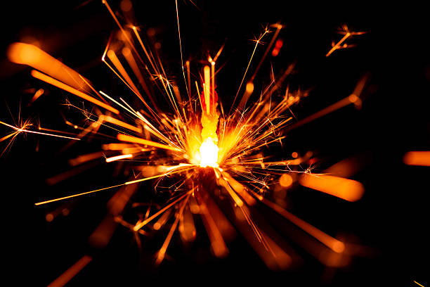 istock Bright Sparkler Firework Creating Bursts of Light Against a Black Background 2207911353