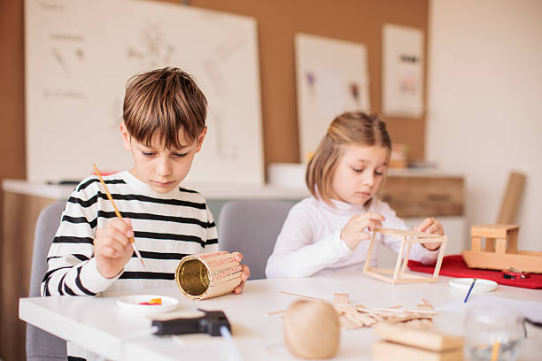 istock Brother and sister attending a woodworking class together 2207911540
