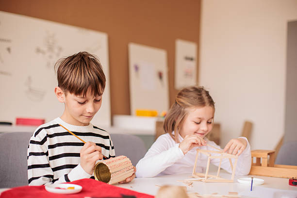 istock Brother and sister attending a woodworking class together 2207911544