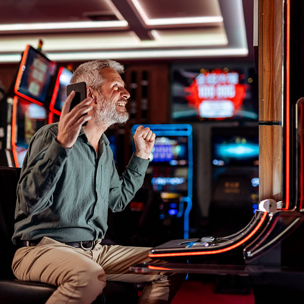 istock Smiling Man Celebrating Victory in Modern Casino Gaming Environment 2207911817