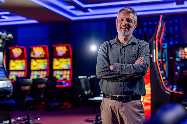 istock Confident Man Smiling Inside a Lively Casino with Slot Machines 2207912821