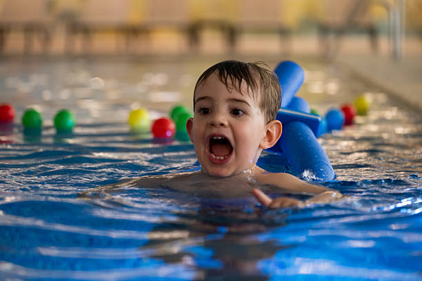 istock Child having fun swimming with float in indoor pool 2207913742