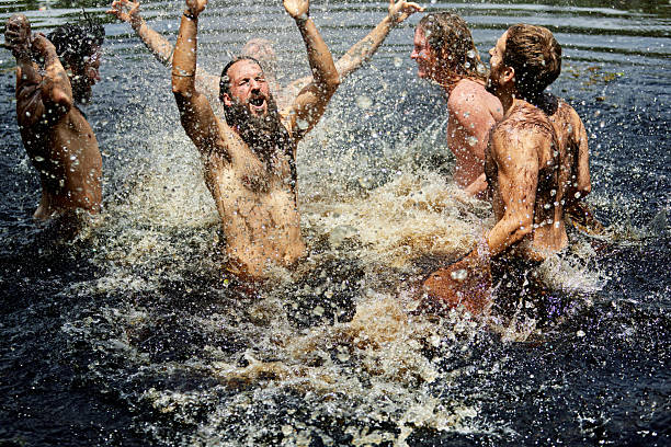 istock Ecstatic men jumping with joy in springtime lake water 2207914526