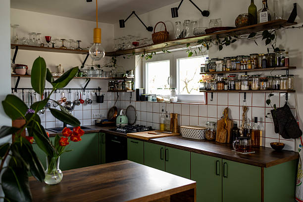 istock Cozy green kitchen with open shelving displaying spices and utensils 2207915015