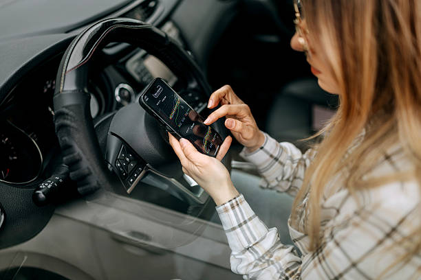 istock Woman checking trading charts on her smartphone while sitting in a car 2207920174