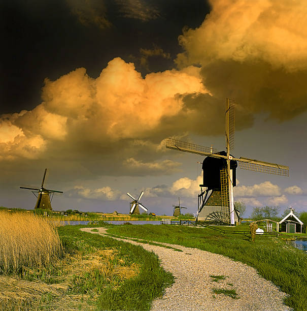 Dutch windmills of Kinderdijk, Holland, UNESCO World Heritage Site - windmill at a water canal with dramatic clouds