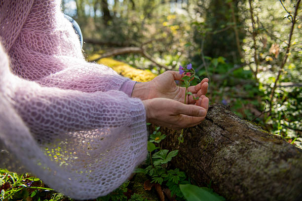 Woman embracing spring flowers in the forest