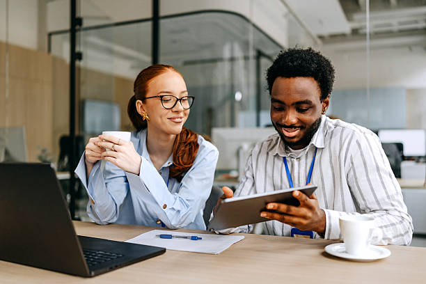 istock Young diverse colleagues collaborating on a digital tablet at the office 2207921707