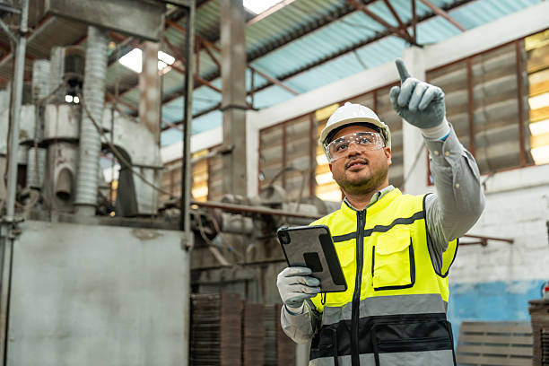 istock Confident engineer man with safety helmet standing analyzing with tablet in factory warehouse. Asian technician factory inspection and control machinery in industry factory. 2207923063