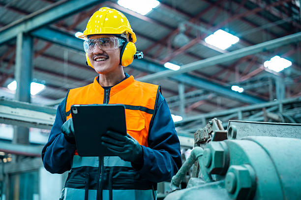 istock Confident engineer man with safety helmet standing analyzing with tablet in factory warehouse. Asian technician factory inspection and control machinery in industry factory. 2207923081