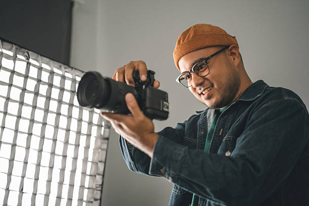 istock Professional man photographer working shooting woman model using digital camera and flash studio in studio on white background. photography concept. 2207923305