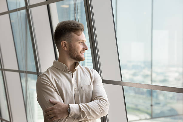 istock Positive confident young entrepreneur in casual standing with hands folded 2207923859