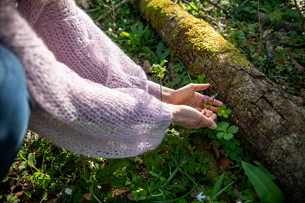 Woman embracing spring flowers in the forest