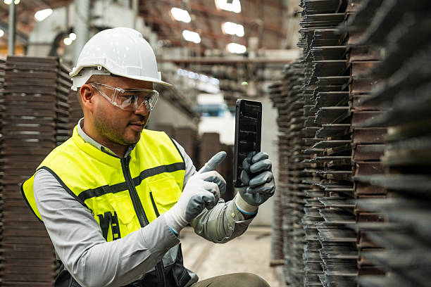 istock Confident engineer man with safety helmet standing analyzing with tablet in factory warehouse. Asian technician factory inspection and control machinery in industry factory. 2207923891