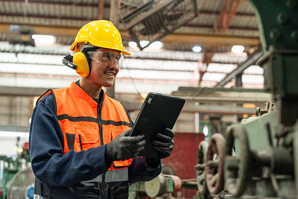 istock Confident engineer man with safety helmet standing analyzing with tablet in factory warehouse. Asian technician factory inspection and control machinery in industry factory. 2207926388