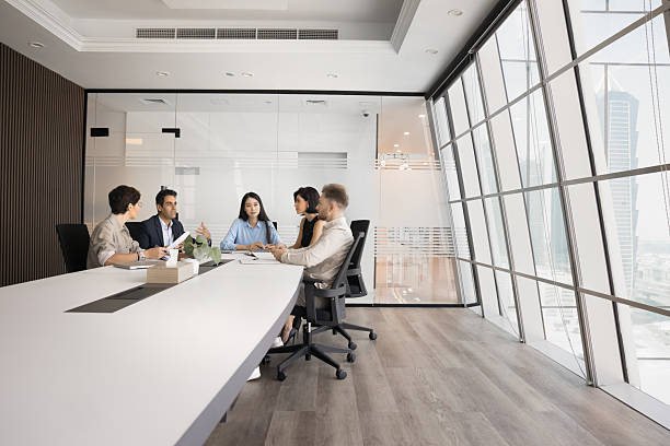 istock Diverse group of company stakeholders talking at large table 2207926599