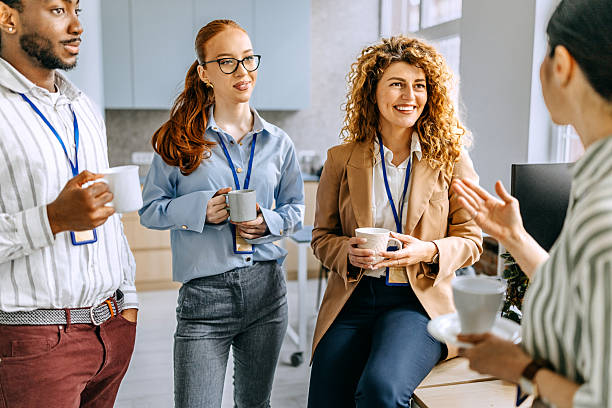 istock Smiling colleagues talking during coffee break at the office 2207927192