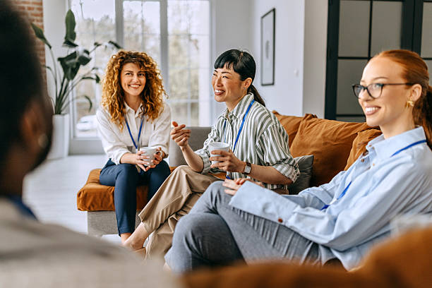 istock Relaxed coworkers talking in the office lounge area 2207927216