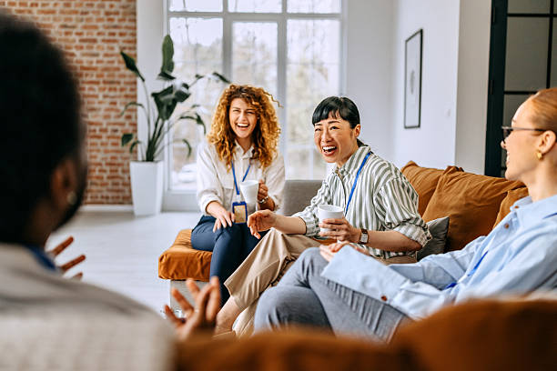 istock Relaxed coworkers talking in the office lounge area 2207927220