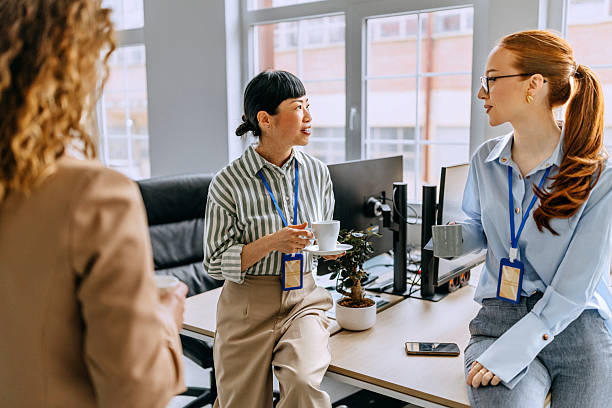 istock Coworkers talking and drinking coffee at office 2207927305
