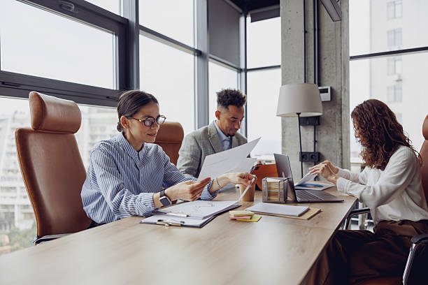 istock Team Meeting Taking Place in a Modern Office Space Equipped with Papers and Laptops 2207927639